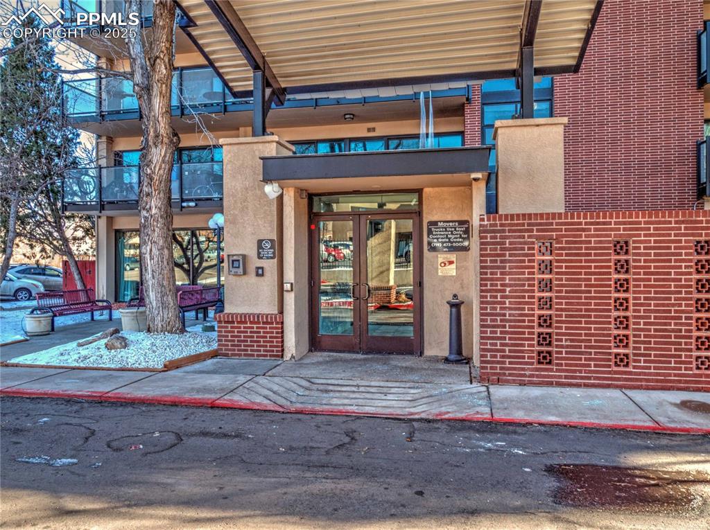 Image 28 of 32: Doorway to property featuring french doors and brick siding