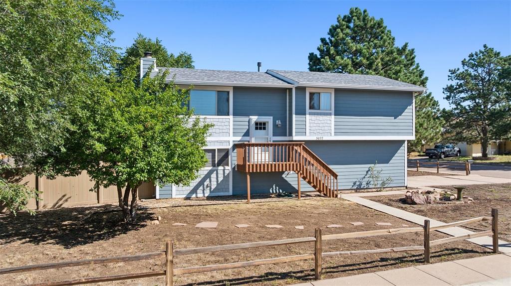 Image 2 of 33: View of front facade with stairs, a chimney, and a shingled roof