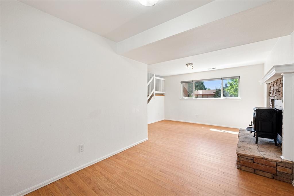 Image 22 of 33: living room featuring a wood stove, light wood-style floors, and stairway