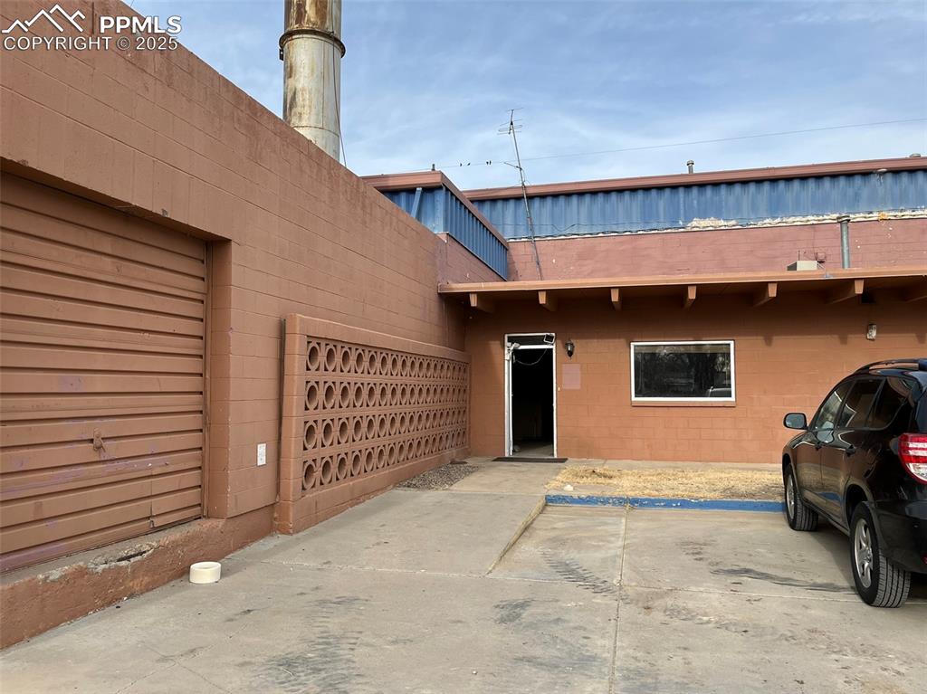 Image 4 of 23: Property entrance with concrete block siding
