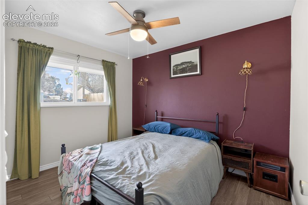 Image 13 of 19: Wood-finish flooring, ceiling fan with integrated lighting, and a window wi