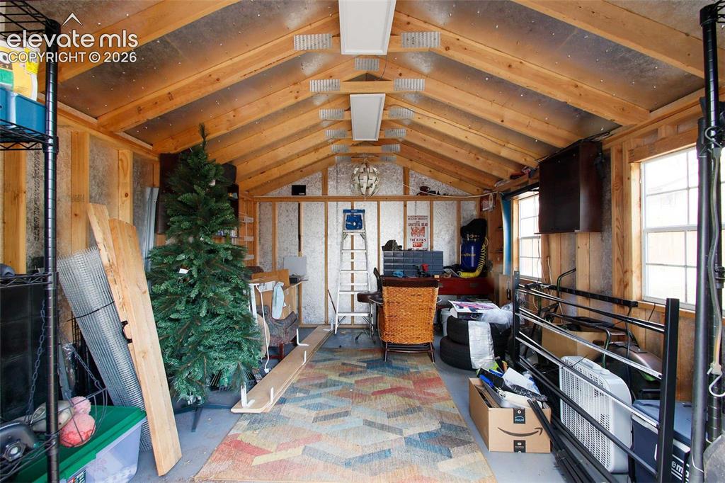 Image 19 of 19: Vaulted wood-beam ceiling with exposed rafters and reflective insulation
