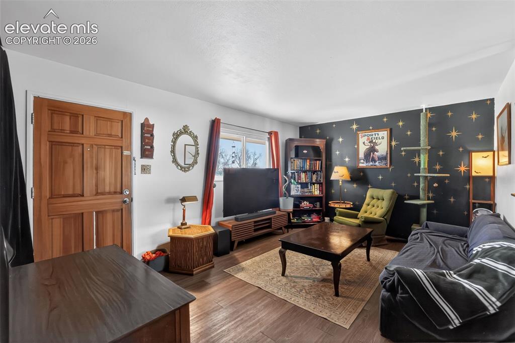 Image 8 of 19: Wood-finish flooring throughout, solid wood entry door, and a built-in shel