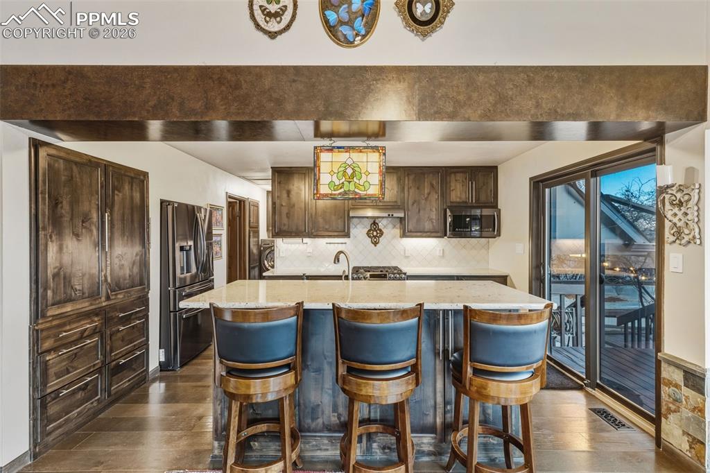 Image 10 of 46: Custom cabinets with a functional kitchen, walk out to patio with grape orc