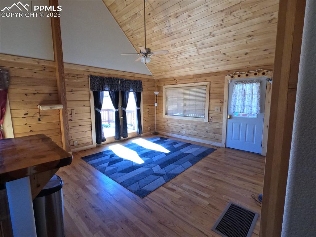 Image 5 of 23: Entryway with wood walls, wood ceiling, wood finished floors, high vaulted 