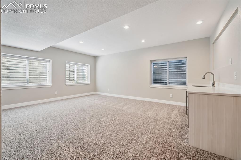 Image 10 of 39: Unfurnished living room with light carpet, recessed lighting, and a texture