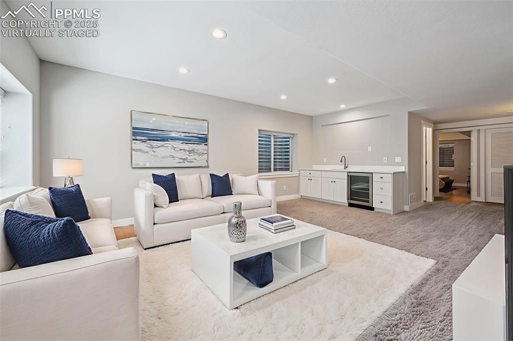Image 11 of 39: Virtually Staged Living area with recessed lighting, light carpet, and beve