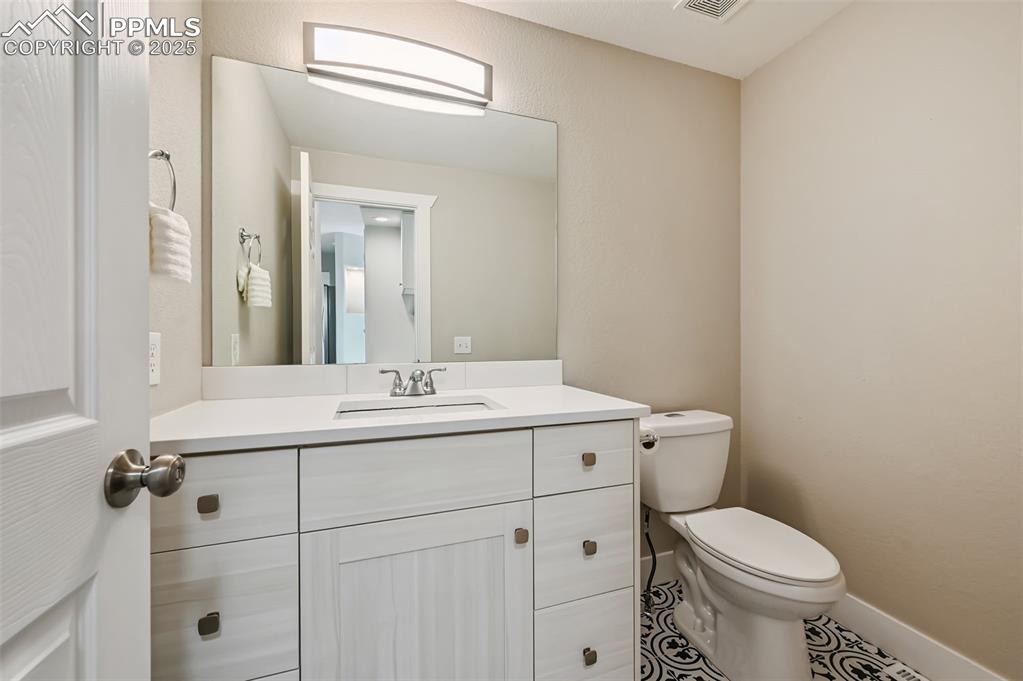 Image 14 of 39: Bathroom with vanity, a textured wall, and tile patterned flooring