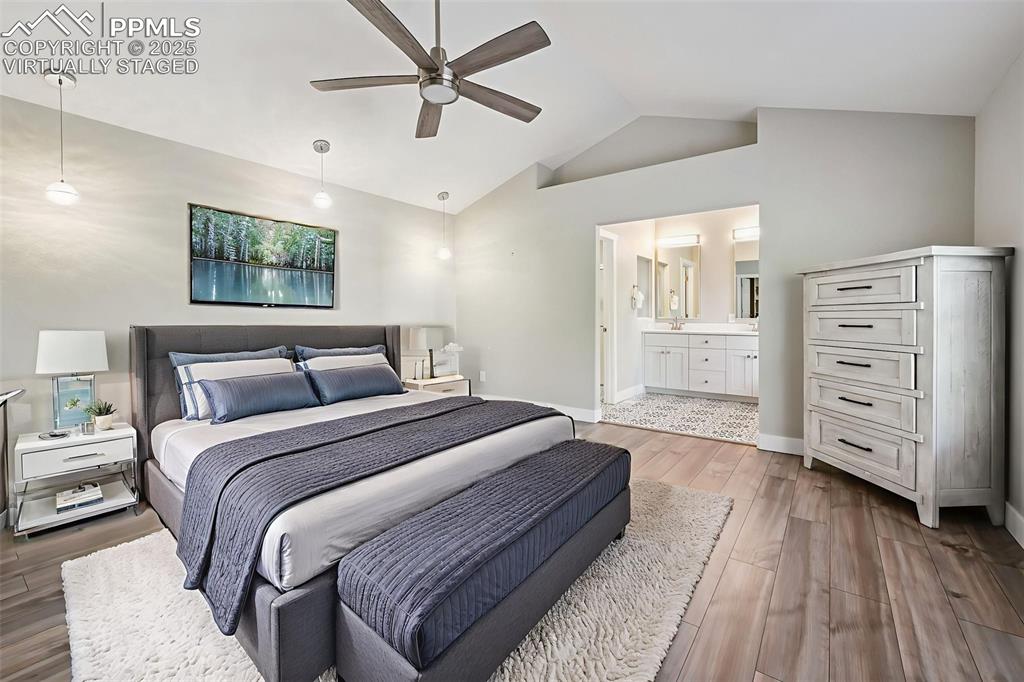 Image 16 of 39: Virtually Staged Bedroom featuring wood finished floors, ceiling fan, ensui