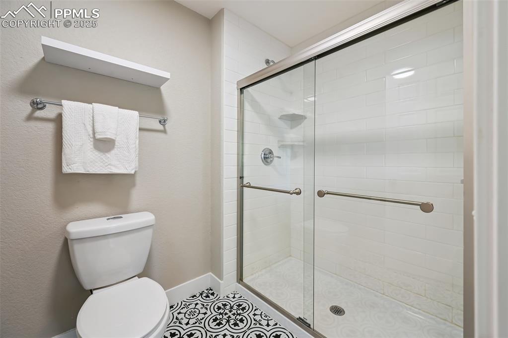 Image 21 of 39: Bathroom with a stall shower and tile patterned floors