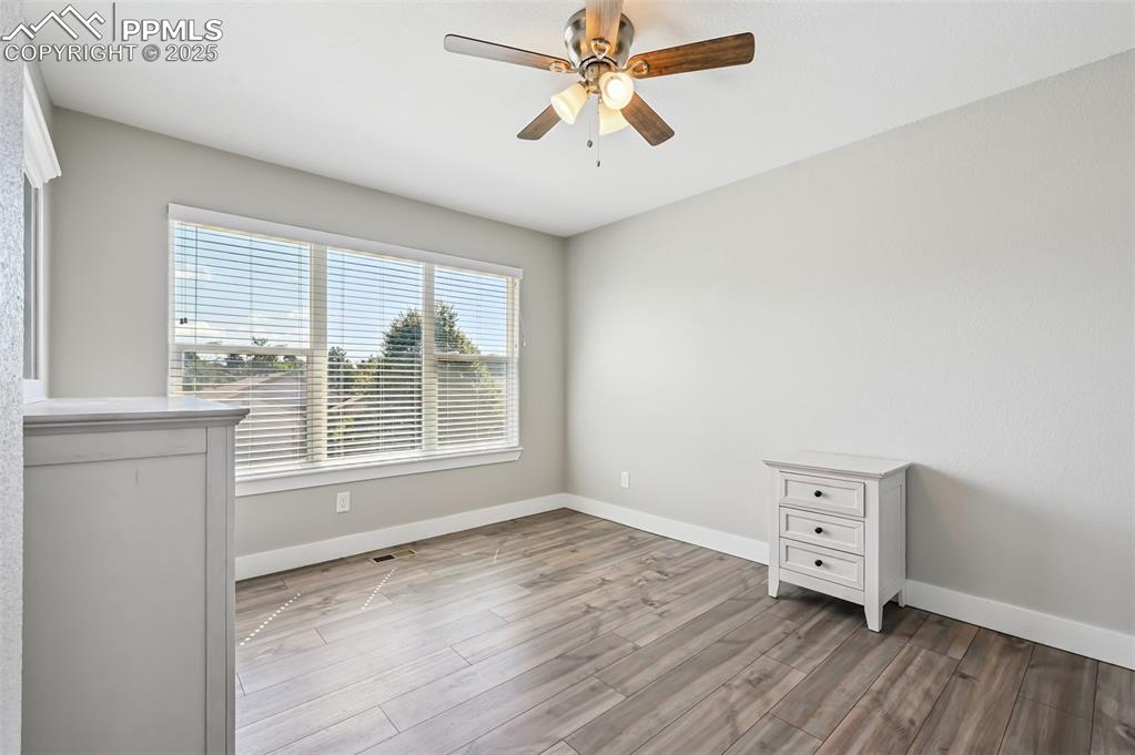 Image 24 of 39: Unfurnished bedroom with light wood finished floors and ceiling fan