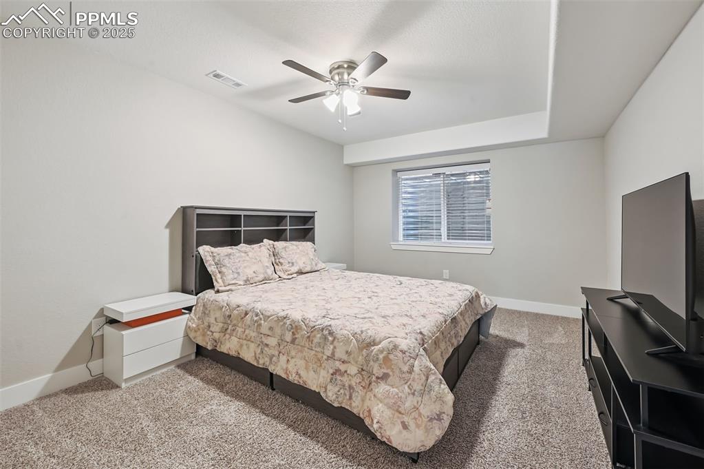 Image 33 of 39: Bedroom with light colored carpet and ceiling fan