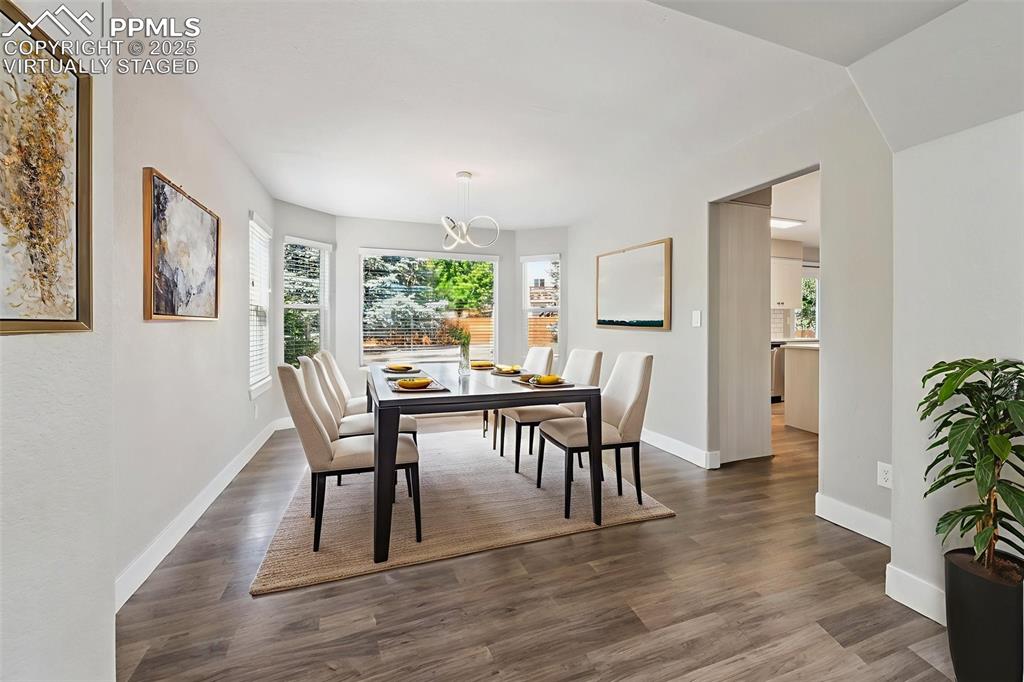 Image 6 of 39: Virtually Staged Dining area featuring wood finished floors and baseboards