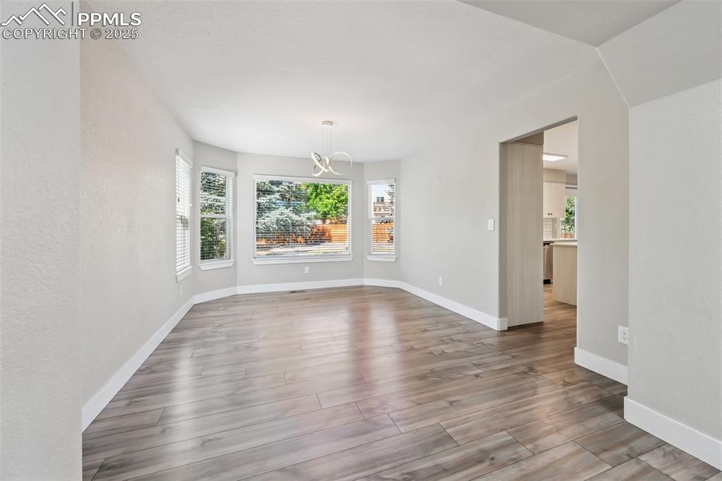 Image 7 of 39: Unfurnished dining area with light wood-type flooring, healthy amount of na
