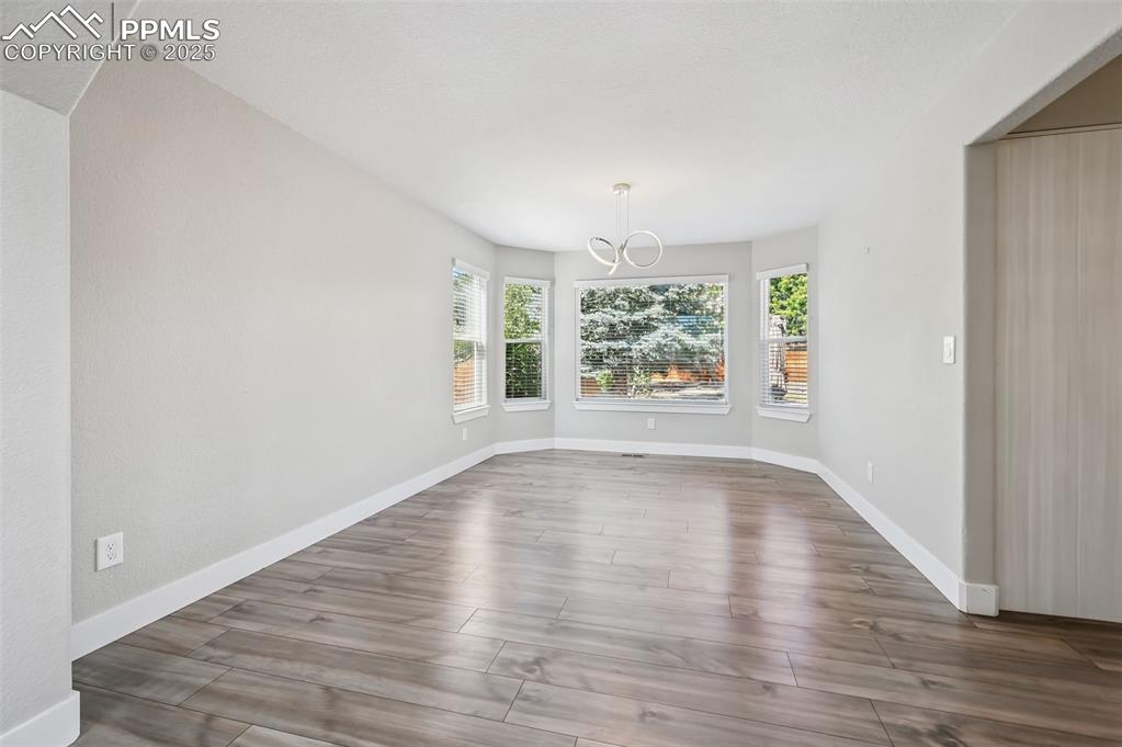 Image 8 of 39: Unfurnished dining area with wood finished floors