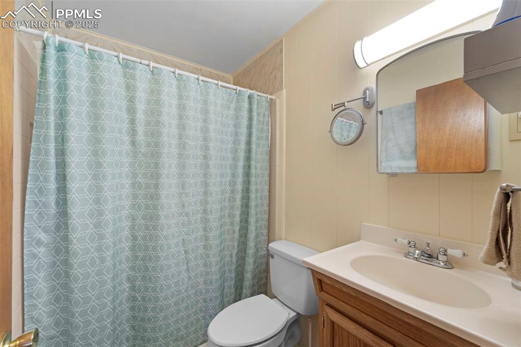 Image 13 of 31: Full bathroom featuring toilet, vanity, and a shower with curtain