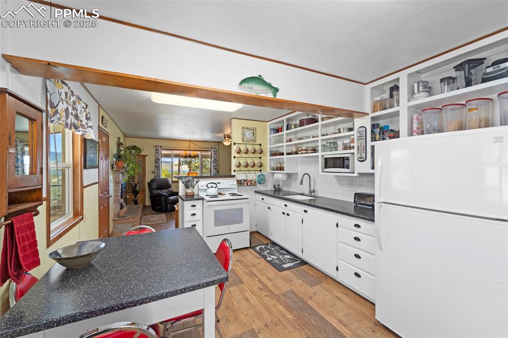 Image 15 of 31: Kitchen open concept to living room and water views.