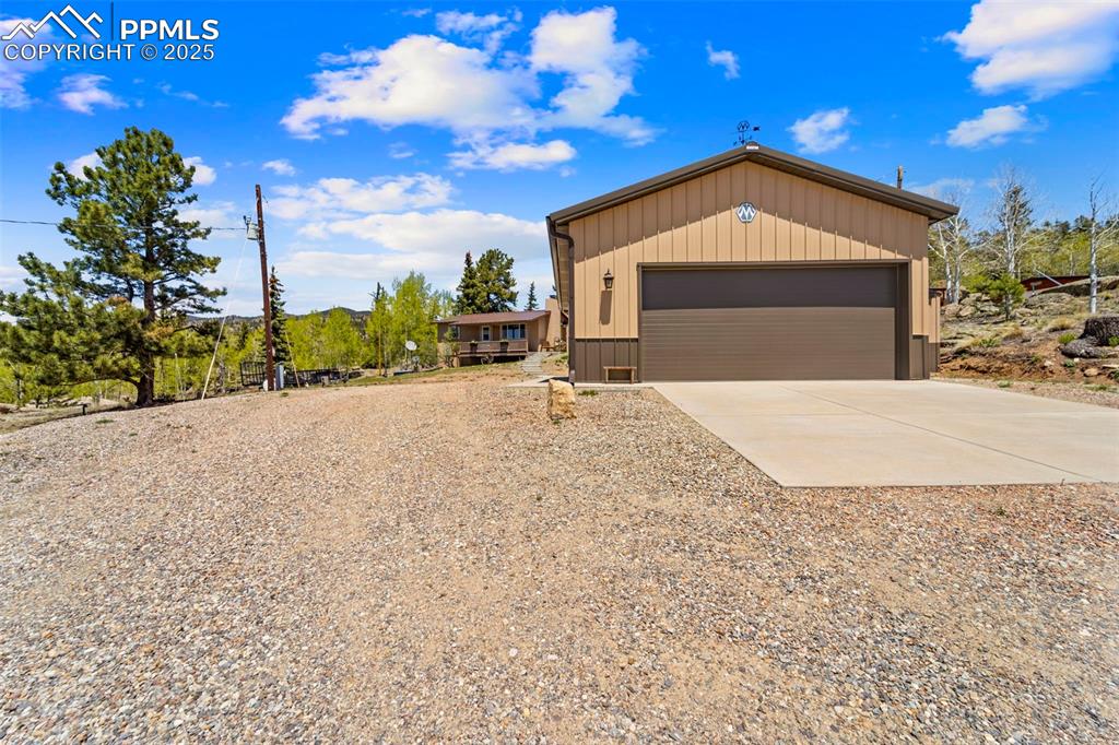 Image 19 of 31: View of front of property featuring a detached garage and driveway