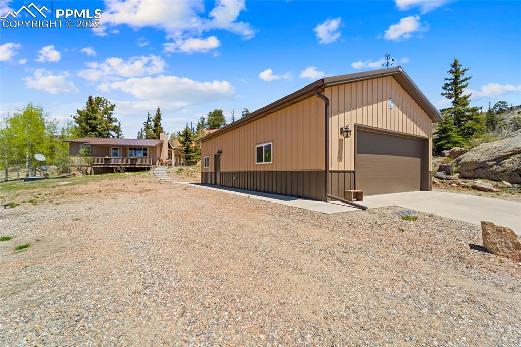 Image 22 of 31: View of side of property with an outbuilding, a garage, and board and batte