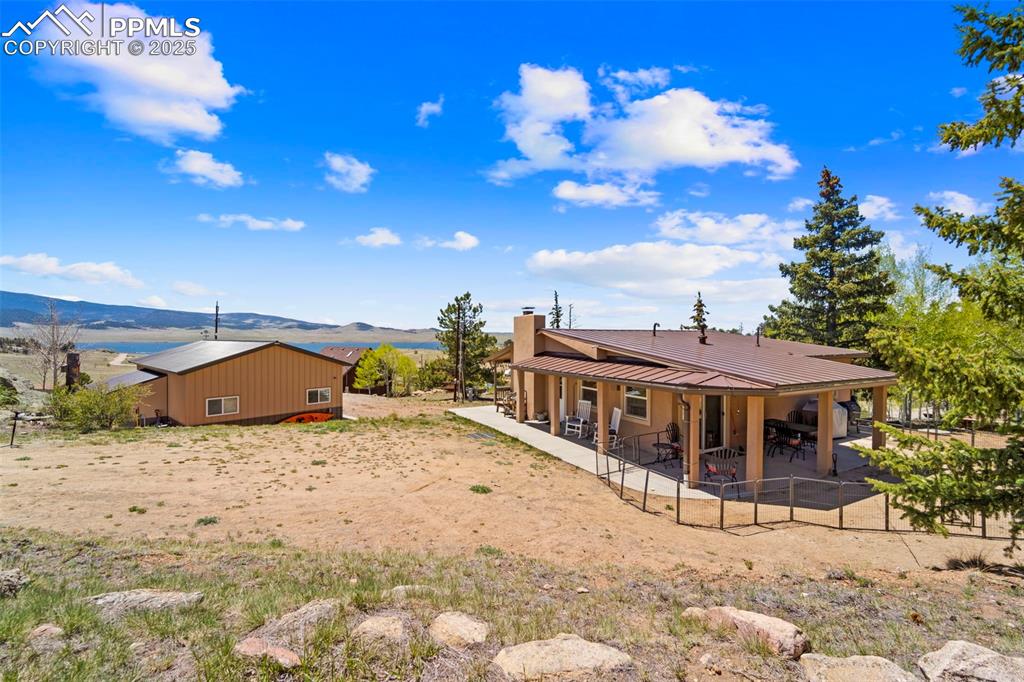 Image 6 of 31: Rear driveway to the home with back patio and water views.