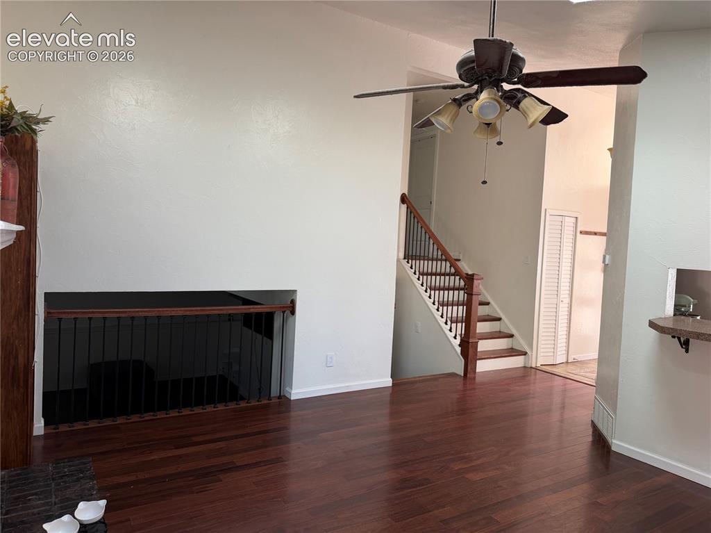 Image 17 of 21: Hardwood flooring, wood-finish staircase with dark iron balusters, ceiling