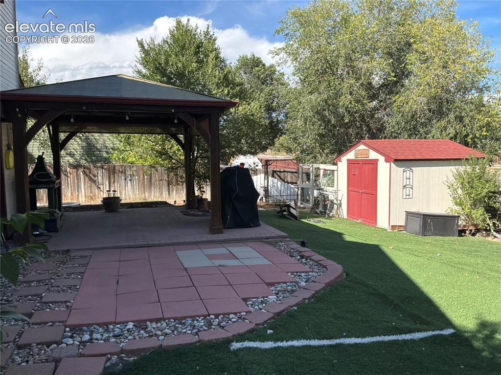 Image 21 of 21: Covered patio structure with a concrete pad, a separate paver patio area, a
