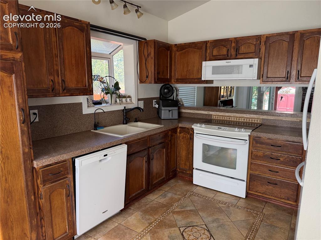 Image 3 of 21: Kitchen featuring wood cabinetry, a double basin sink with a gooseneck fauc