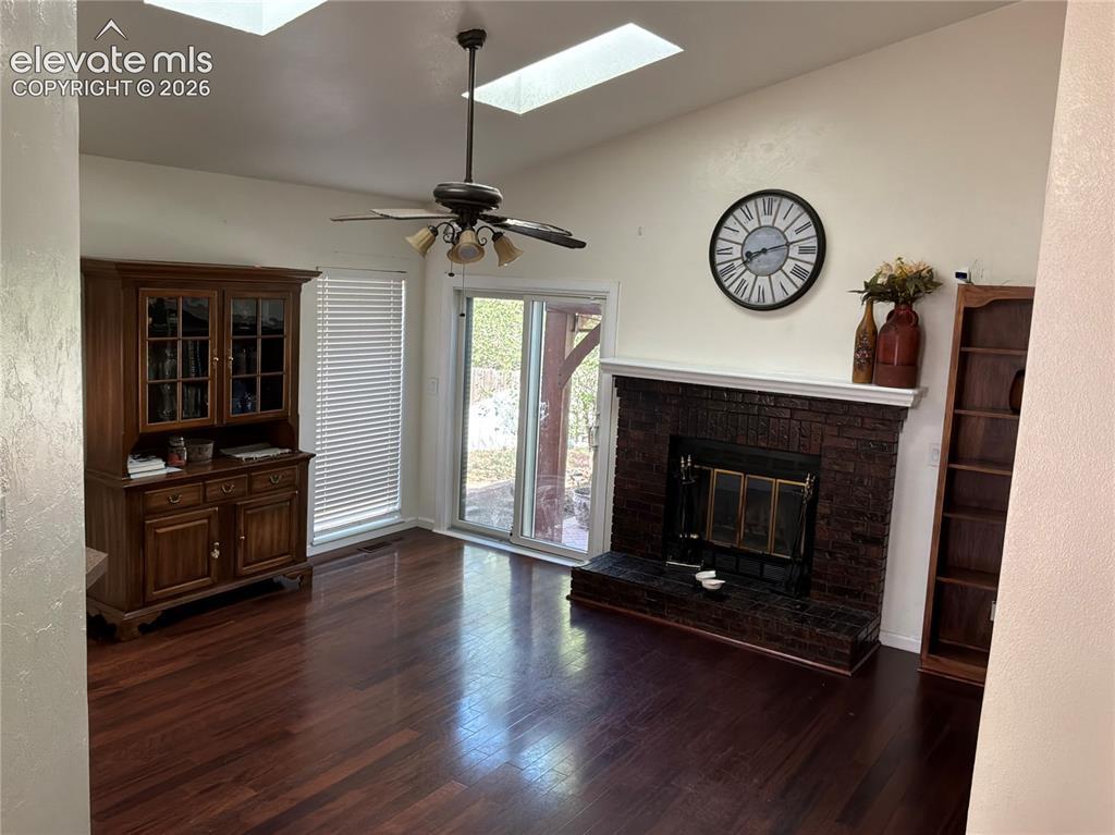 Image 4 of 21: Vaulted ceilings with skylights, rich wood-finish flooring, a brick-front f