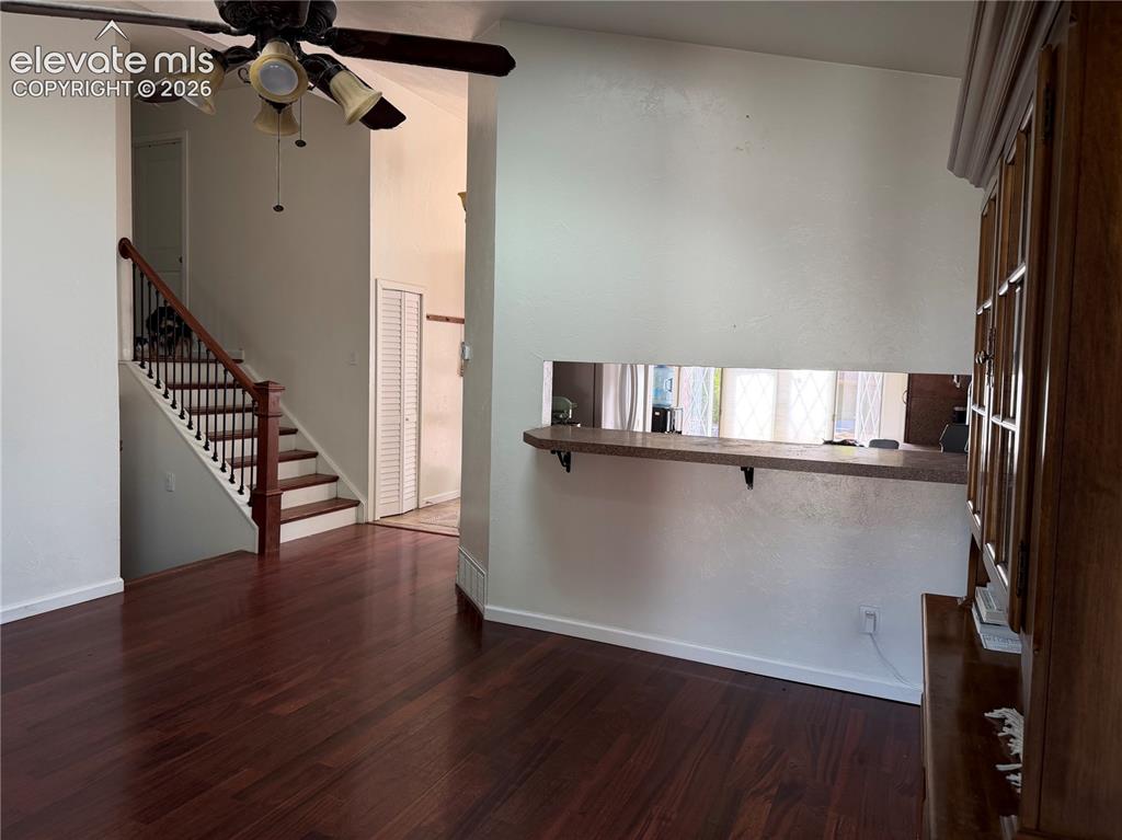 Image 5 of 21: Rich wood-finish flooring, staircase with dark wood handrail and white rise