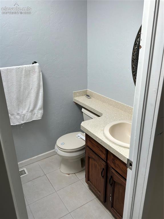 Image 7 of 21: Vanity with a light-colored countertop, integrated sink, and wood-finish ca