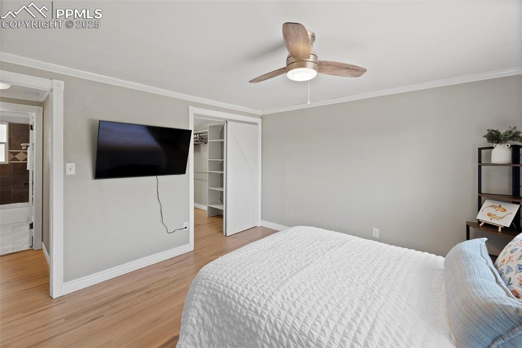 Image 11 of 33: Bedroom with ornamental molding, light wood finished floors, ceiling fan, a