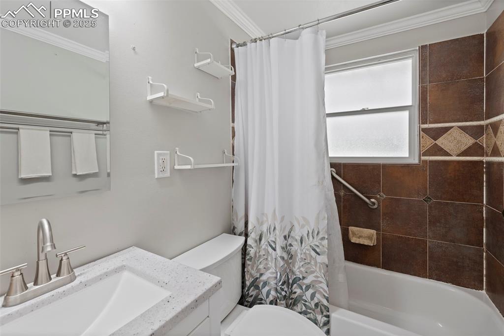 Image 14 of 33: Bathroom featuring vanity, shower / bath combination with curtain, and crow