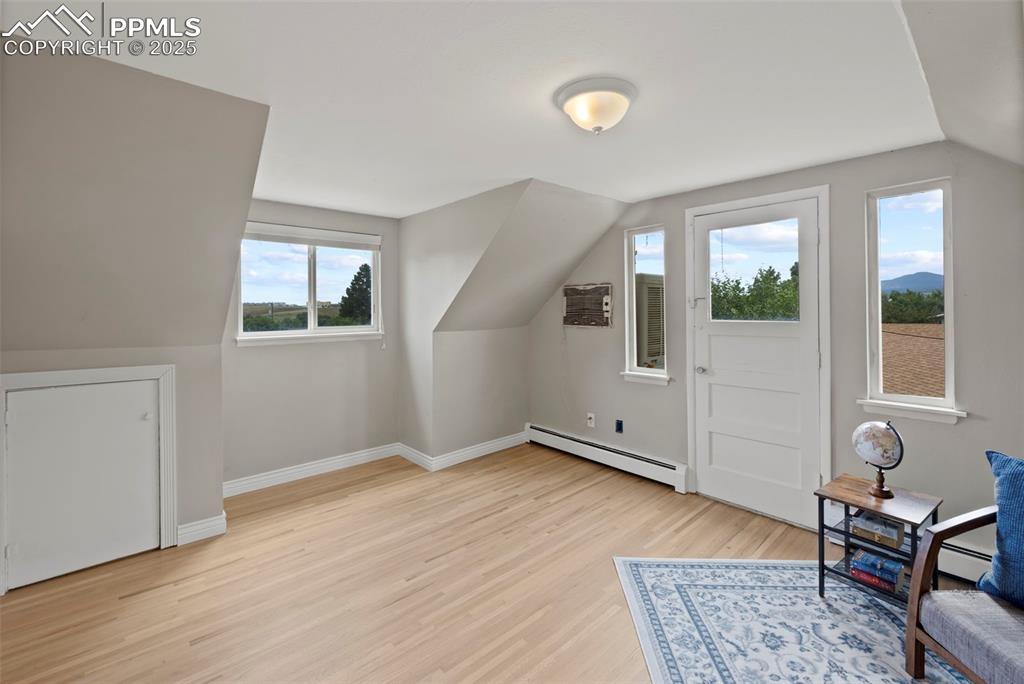 Image 16 of 33: Additional living space with light wood-style floors, baseboard heating, va