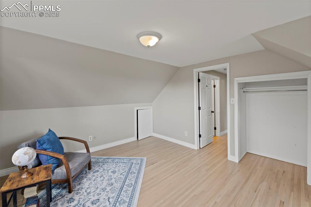 Image 17 of 33: Sitting room with light wood-style flooring and lofted ceiling