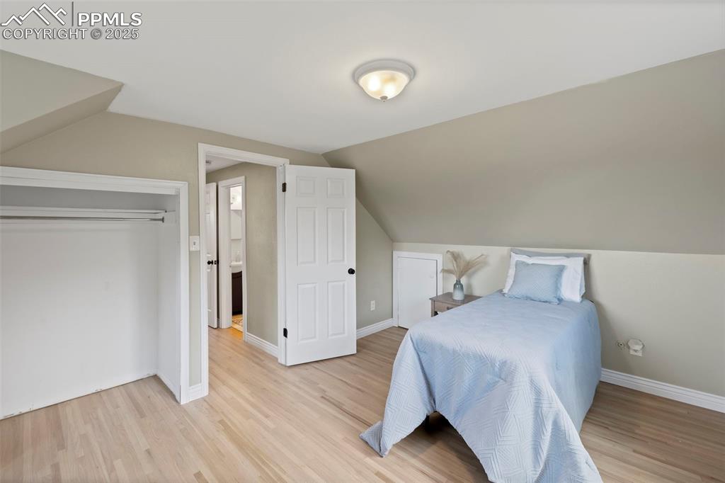 Image 18 of 33: Bedroom featuring light wood finished floors and lofted ceiling