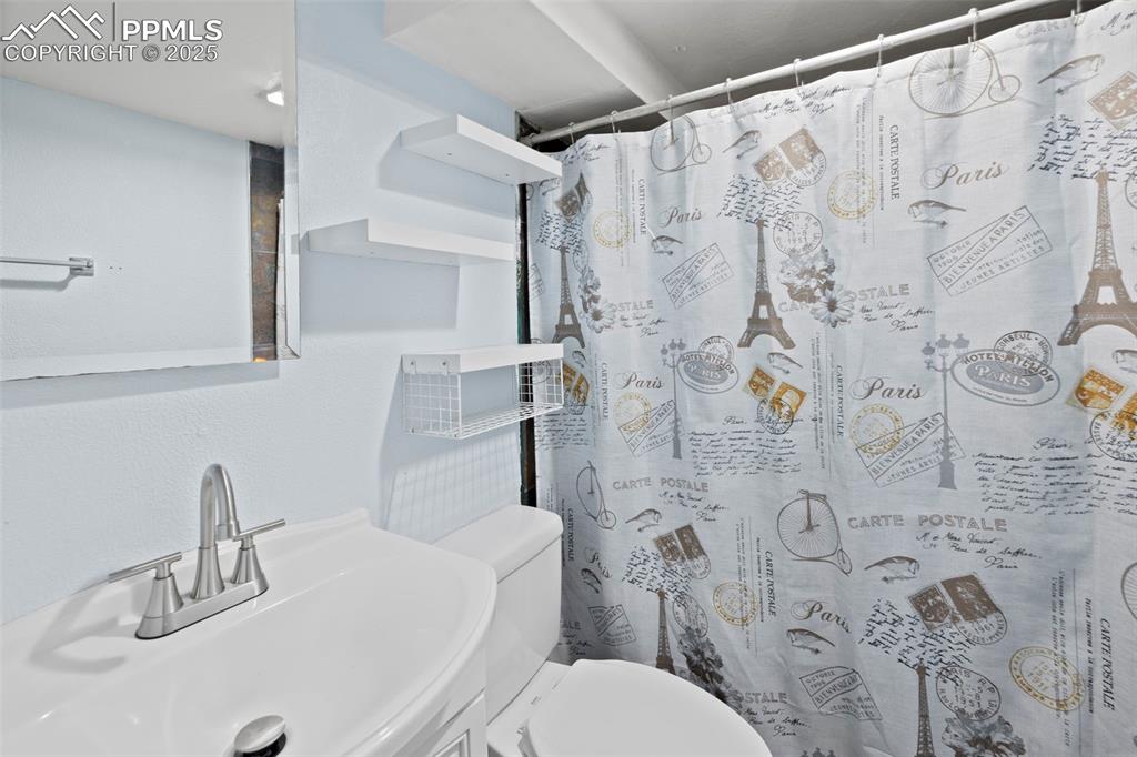 Image 27 of 33: Bathroom featuring curtained shower and vanity