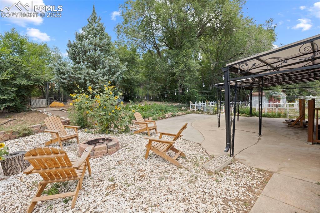 Image 28 of 33: View of yard featuring an outdoor fire pit, a patio area, and view of scatt