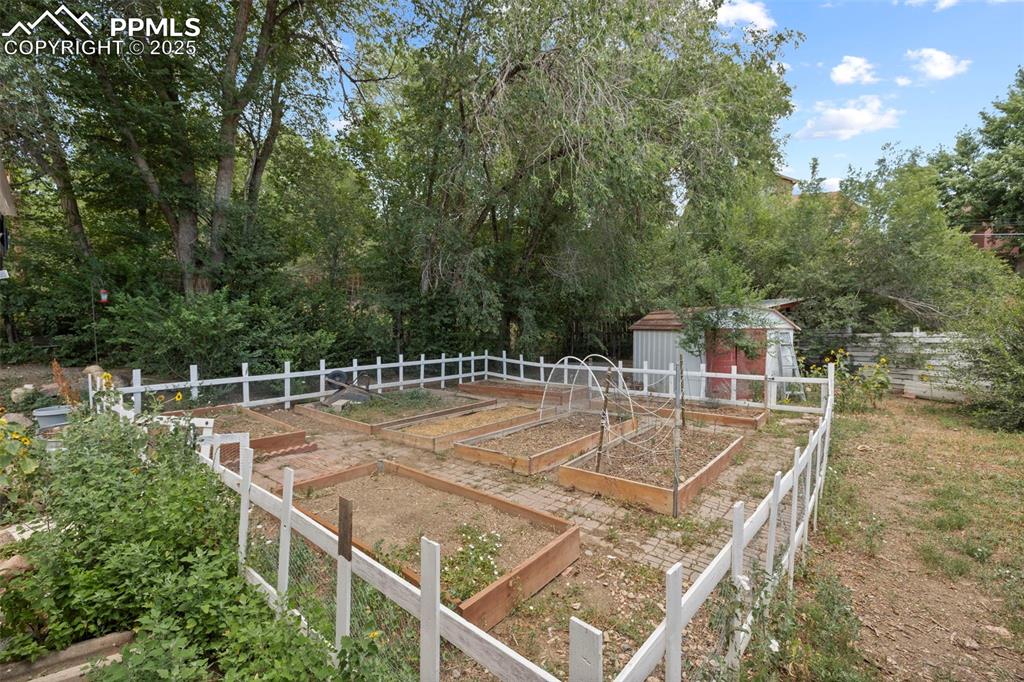 Image 32 of 33: View of yard featuring a shed and a vegetable garden