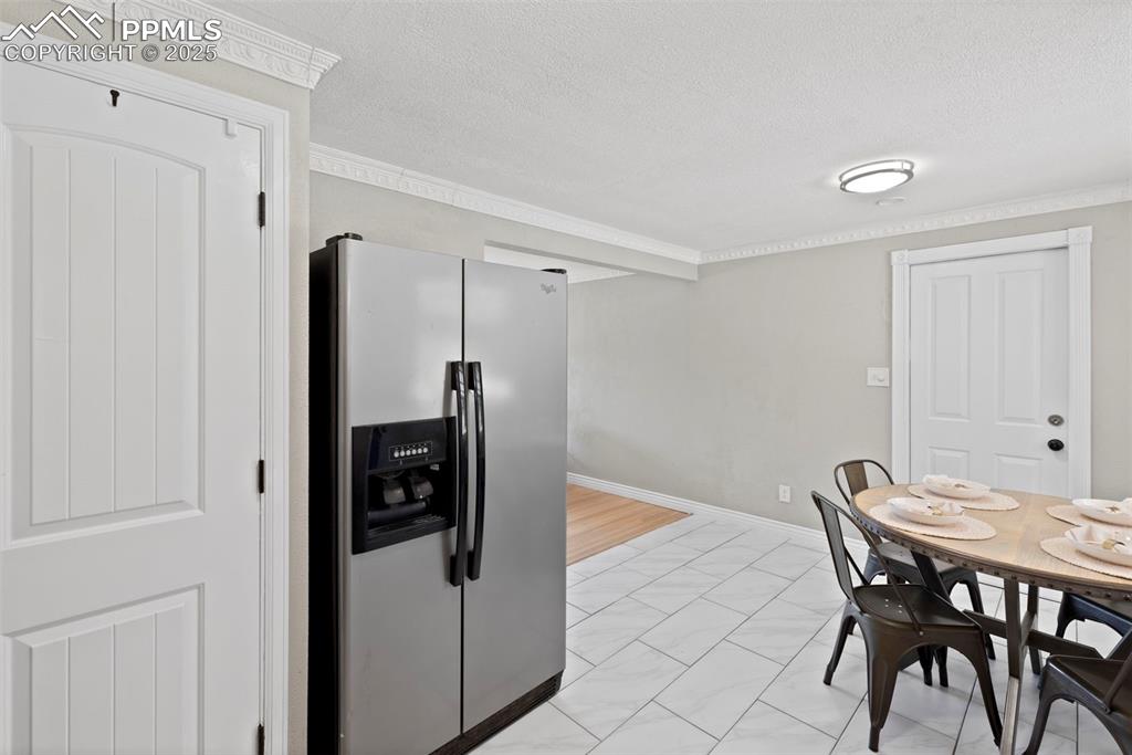 Image 9 of 33: Dining area featuring ornamental molding and a textured ceiling