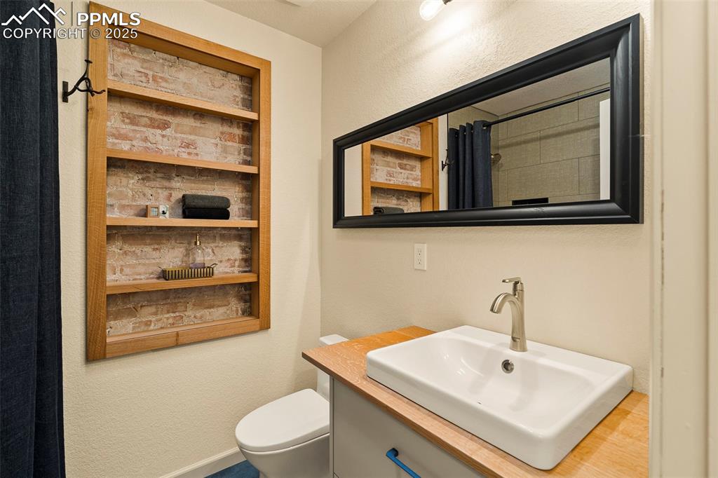 Image 28 of 47: A lovely surprise in the 2nd level full bathroom! Custom built-in shelving 