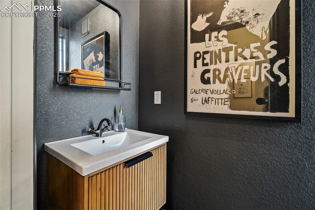 Image 31 of 47: The main level powder room is elegantly dramatic, with a floor-to-ceiling (
