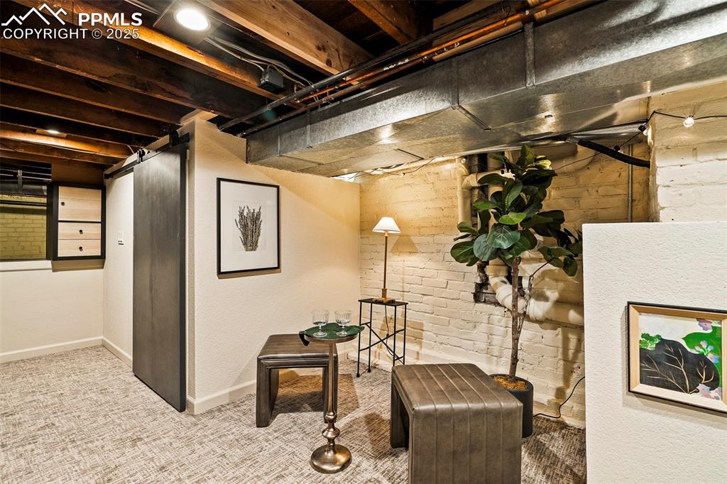 Image 34 of 47: The basement family room celebrates the history of the original structure w