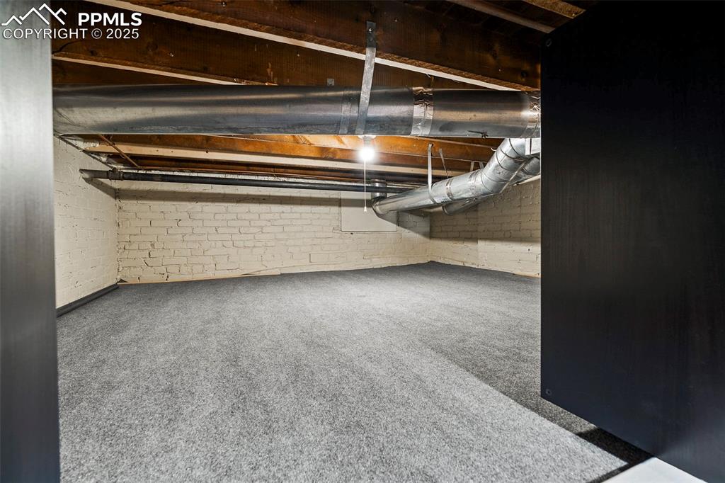 Image 36 of 47: The basement family room celebrates the history of the original structure w