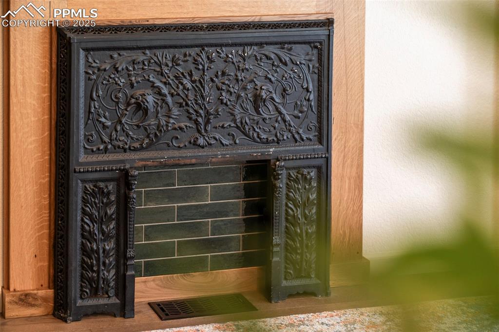 Image 6 of 47: The historic fireplace was salvaged from the rehab. The mantle and iron sur
