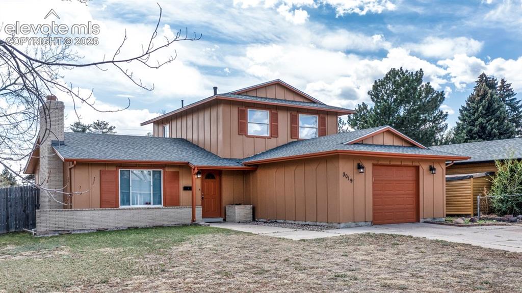 Image 1 of 25: Two-story residence featuring a two-car garage, brick chimney, and board-an