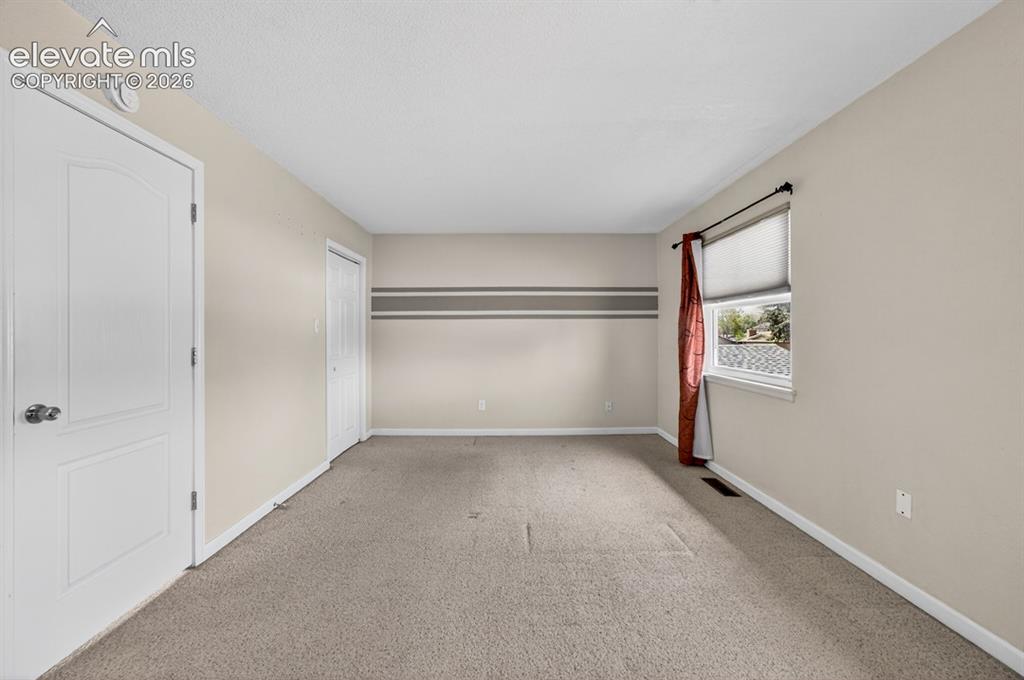Image 15 of 25: Neutral wall paint with accent stripe, white trim, and a window providing n