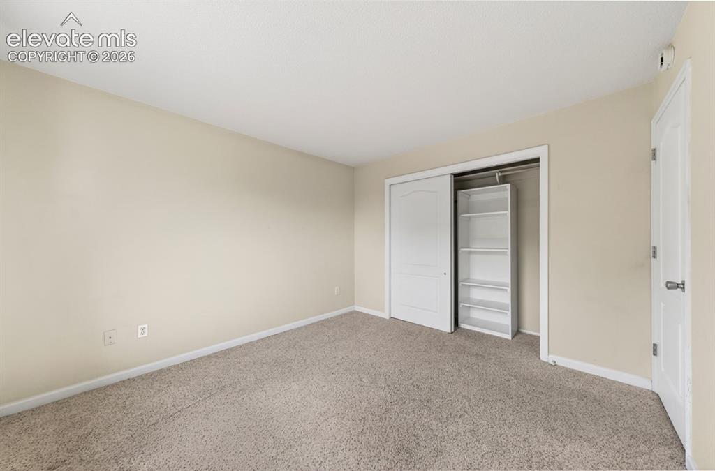 Image 19 of 25: Neutral tone wall paint, light-toned carpet, white trim, sliding closet doo