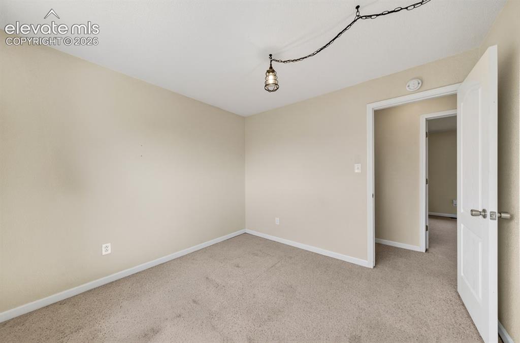 Image 22 of 25: Neutral tone wall paint, carpet flooring, and a ceiling-mounted light fixtu