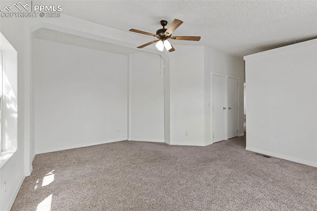 Image 16 of 24: Spare room with carpet, a ceiling fan, and a textured ceiling