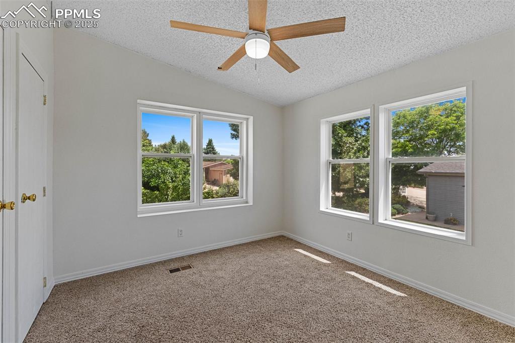 Image 21 of 24: Carpeted spare room featuring a textured ceiling, vaulted ceiling, and ceil